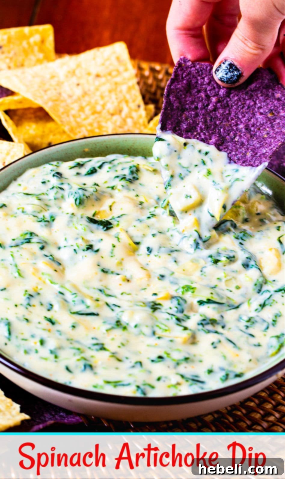 Irresistible Spinach Artichoke Dip 4 Another perspective of the creamy Spinach Artichoke Dip, invitingly warm in a serving bowl, with a few pieces of crispy tortilla chips waiting to scoop up the deliciousness.
