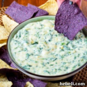 Spinach Artichoke Dip in a bowl with tortilla chips, ready to be served.
