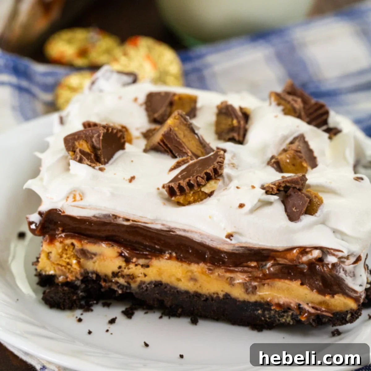 Decadent Peanut Butter Chocolate Stack 2 A perfectly sliced piece of Chocolate Peanut Butter Layer Dessert on a white plate, showcasing its distinct layers.