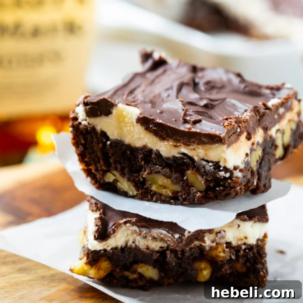 Two rich Double Frosted Bourbon Brownies stacked on top of each other, showcasing their layers of frosting and moist texture.