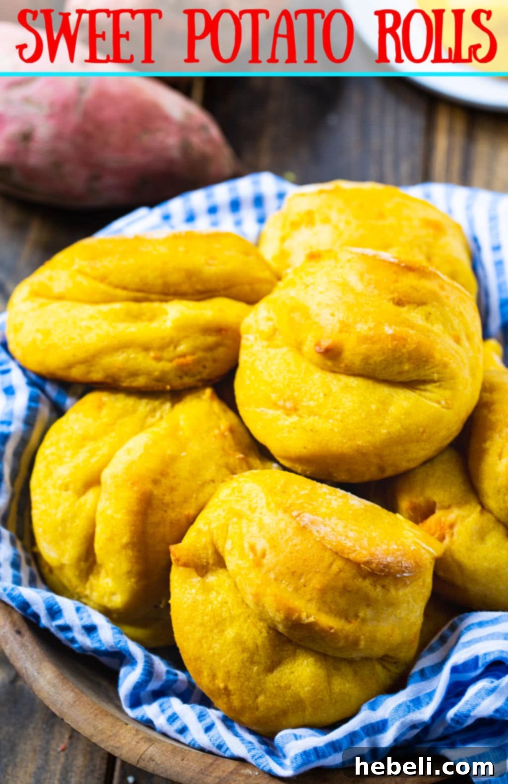 Close-up of golden brown Sweet Potato Rolls, gently folded and glistening with melted butter, presented in a woven basket.