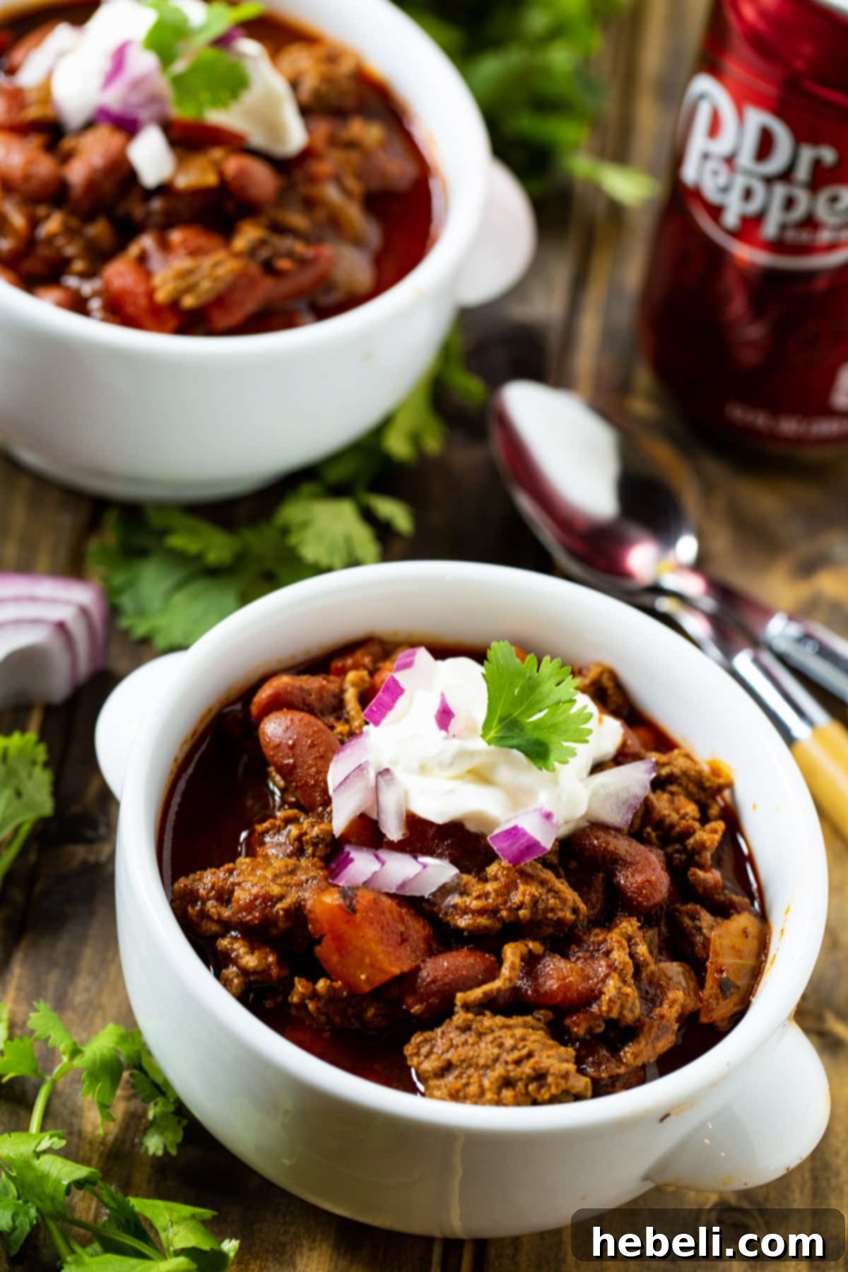 Two enticing bowls of Dr Pepper Chili, their rich, deep red color and texture promising a satisfying meal.