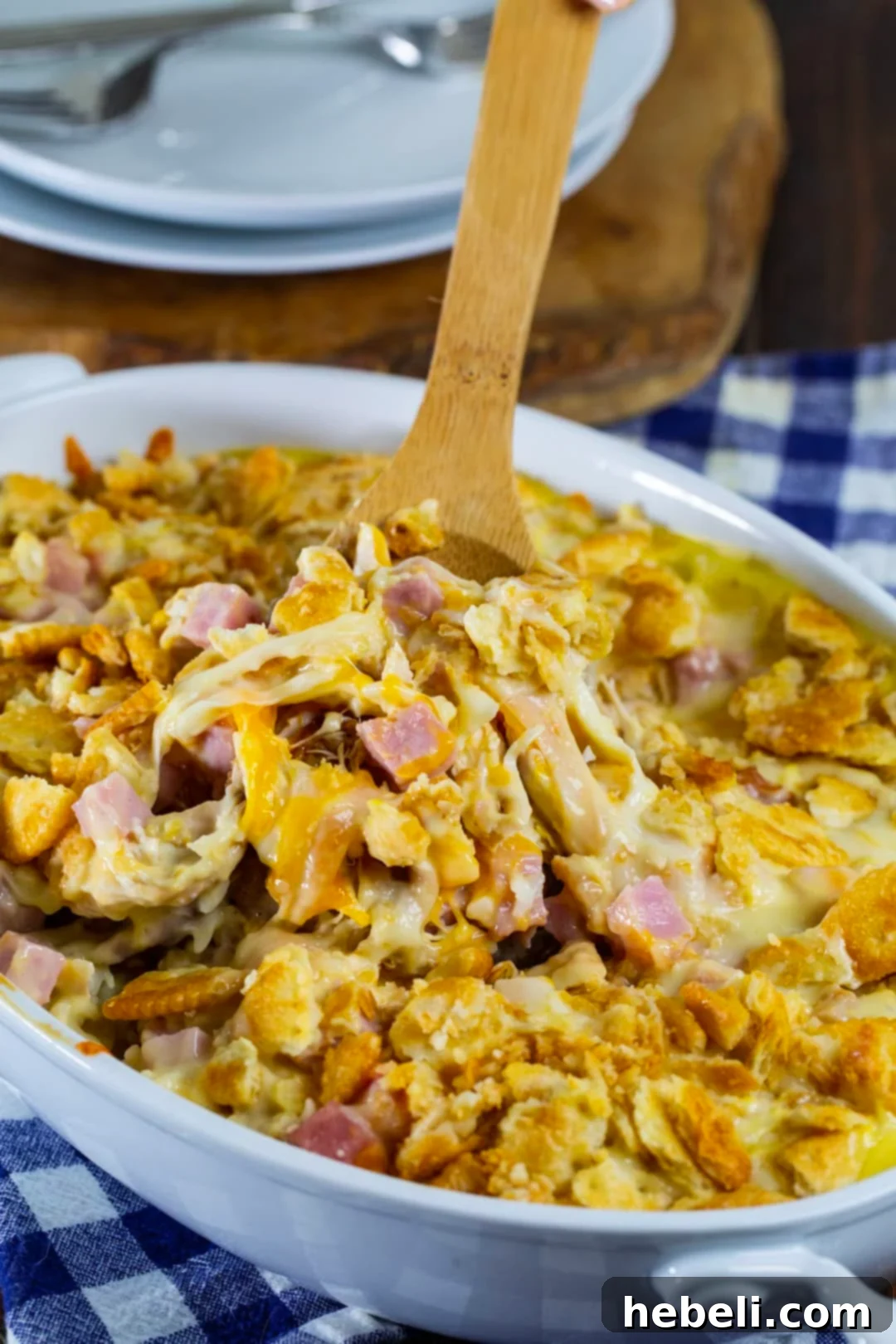 Creamy Chicken Cordon Bleu Bake 4 A wooden spoon scooping up a generous portion of the Chicken Cordon Bleu Casserole.