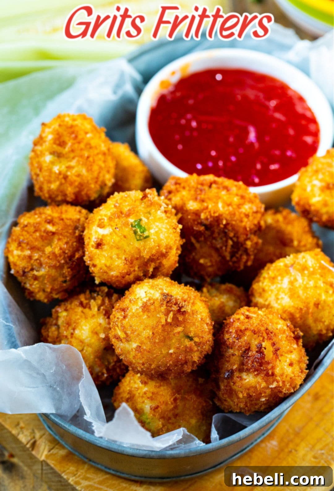 Crispy Grits Fritters in metal serving dish with bowl of dipping sauce.