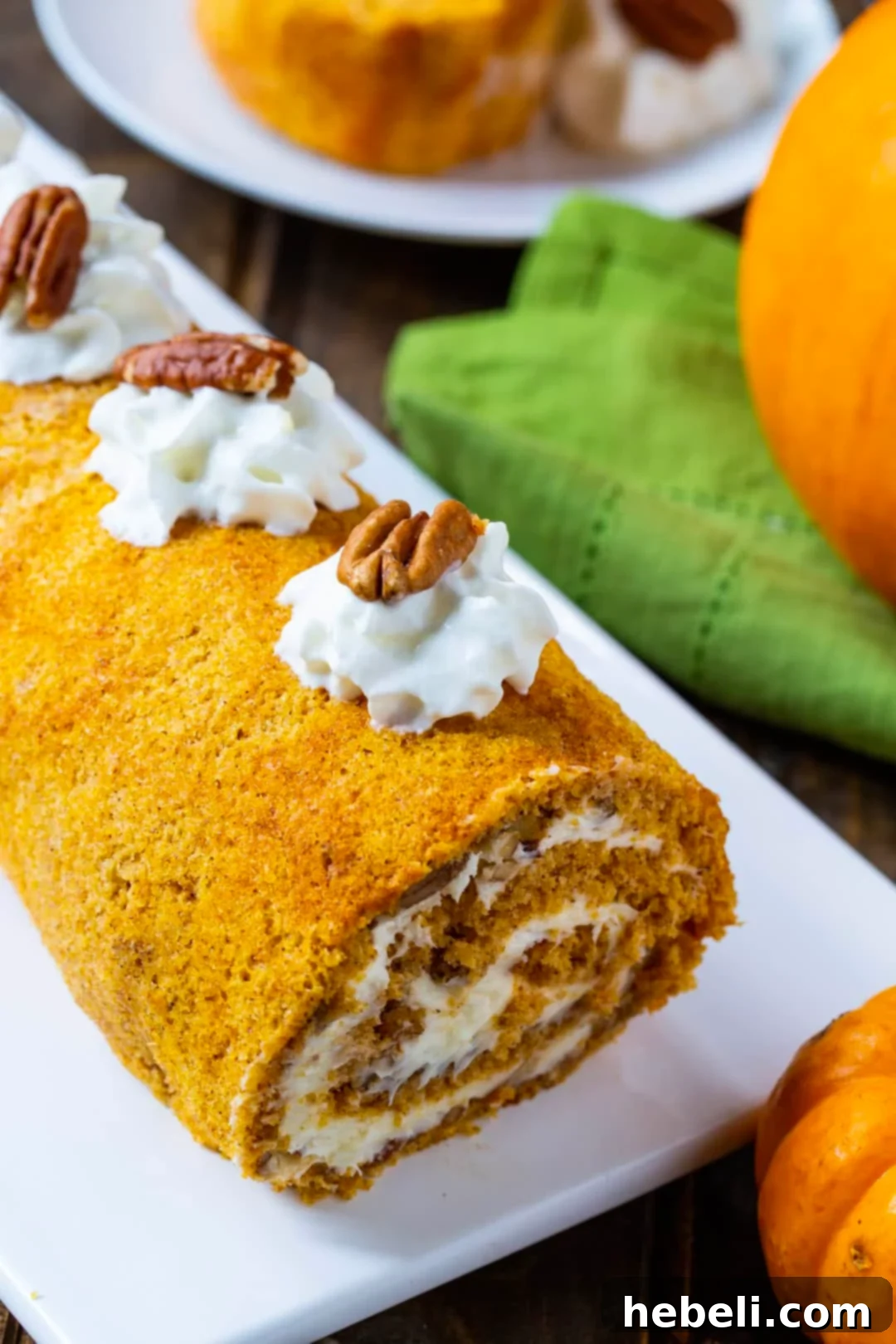 A full, beautifully rolled Pumpkin Cake Roll dusted with powdered sugar, ready to be sliced.