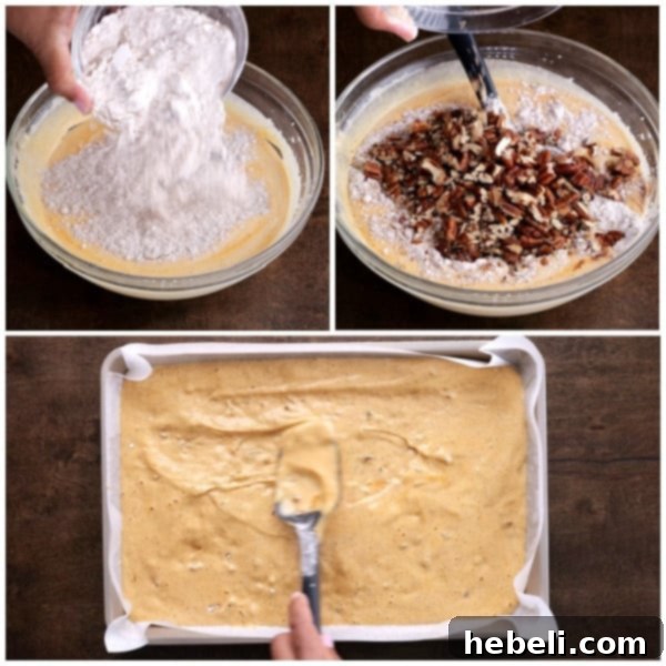 Spreading the finished pumpkin cake batter smoothly into a prepared jelly roll pan before baking.