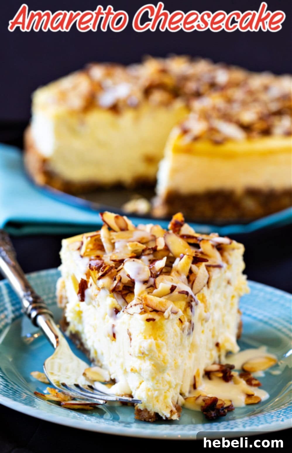 A close-up of a single slice of Amaretto Cheesecake on a plate, featuring the intricate details of the almond topping.