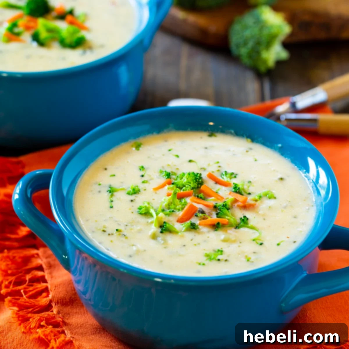 Ultimate Creamy Broccoli Cheese Soup 2 A vibrant blue bowl filled with homemade Broccoli Cheese Soup, garnished with a sprinkle of fresh parsley, showcasing its creamy texture.