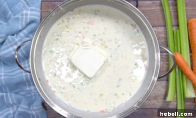Adding the cream cheese to the creamy pot pie filling.