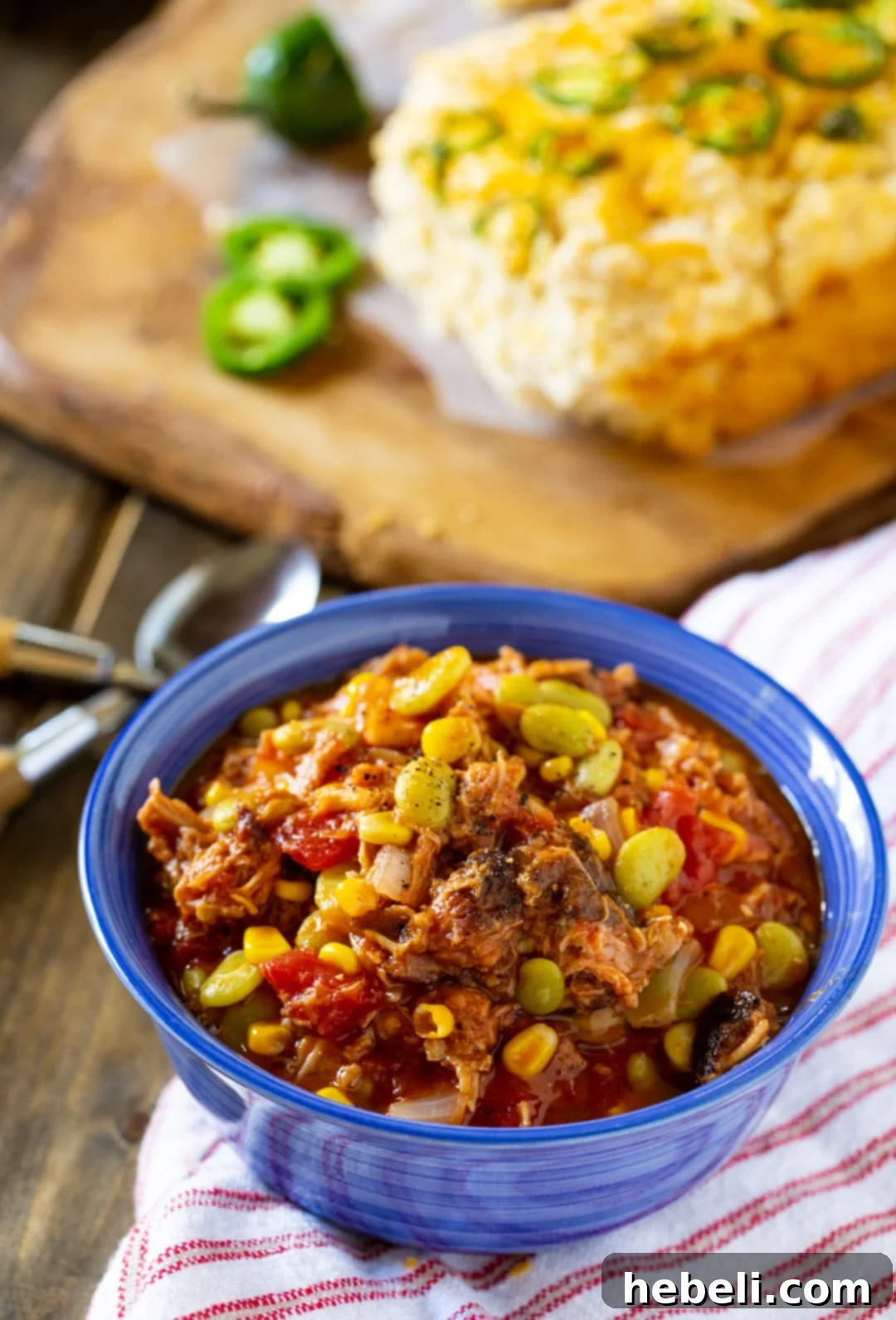 A rustic bowl of Brunswick Stew paired with a fresh loaf of beer bread, inviting a cozy meal.