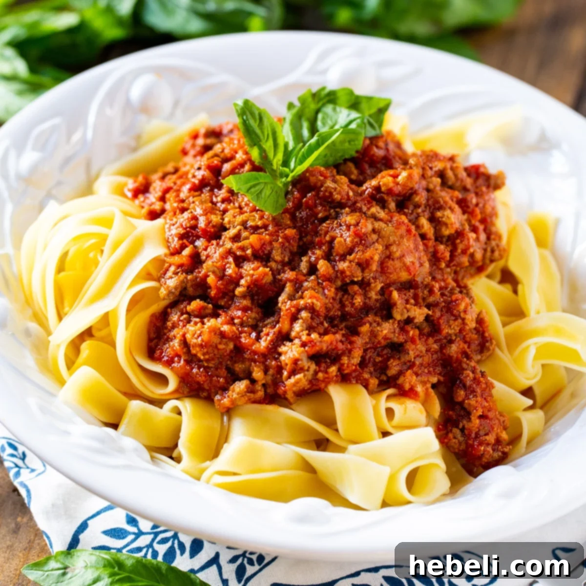 Classic Pappardelle Bolognese 2 A rustic bowl filled with generous portions of pappardelle pasta coated in a rich, meaty Bolognese sauce, garnished with fresh herbs.