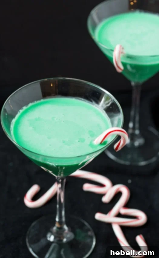 Grasshopper Cocktail in a martini glass, garnished with a candy cane, perfect for holiday celebrations