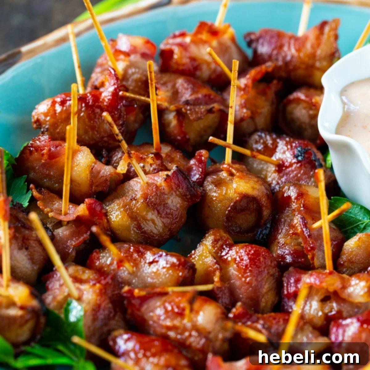 Close-up of golden brown Bacon-Wrapped Water Chestnuts with toothpicks sticking out, arranged on a rustic wooden board.