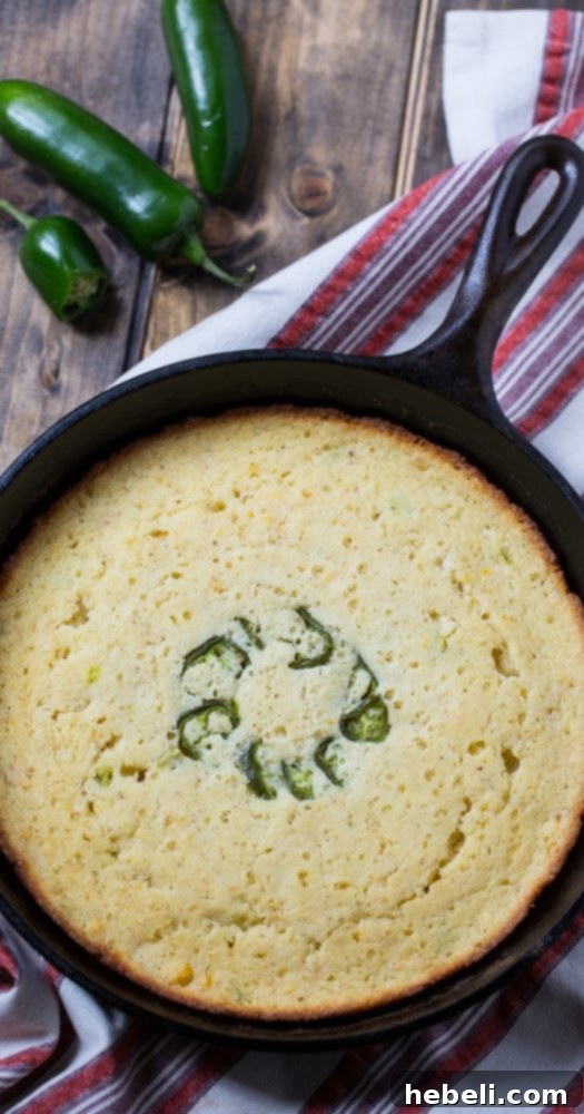 Close-up of a serving of Super Moist Jalapeno Cornbread on a cutting board, ready for slicing