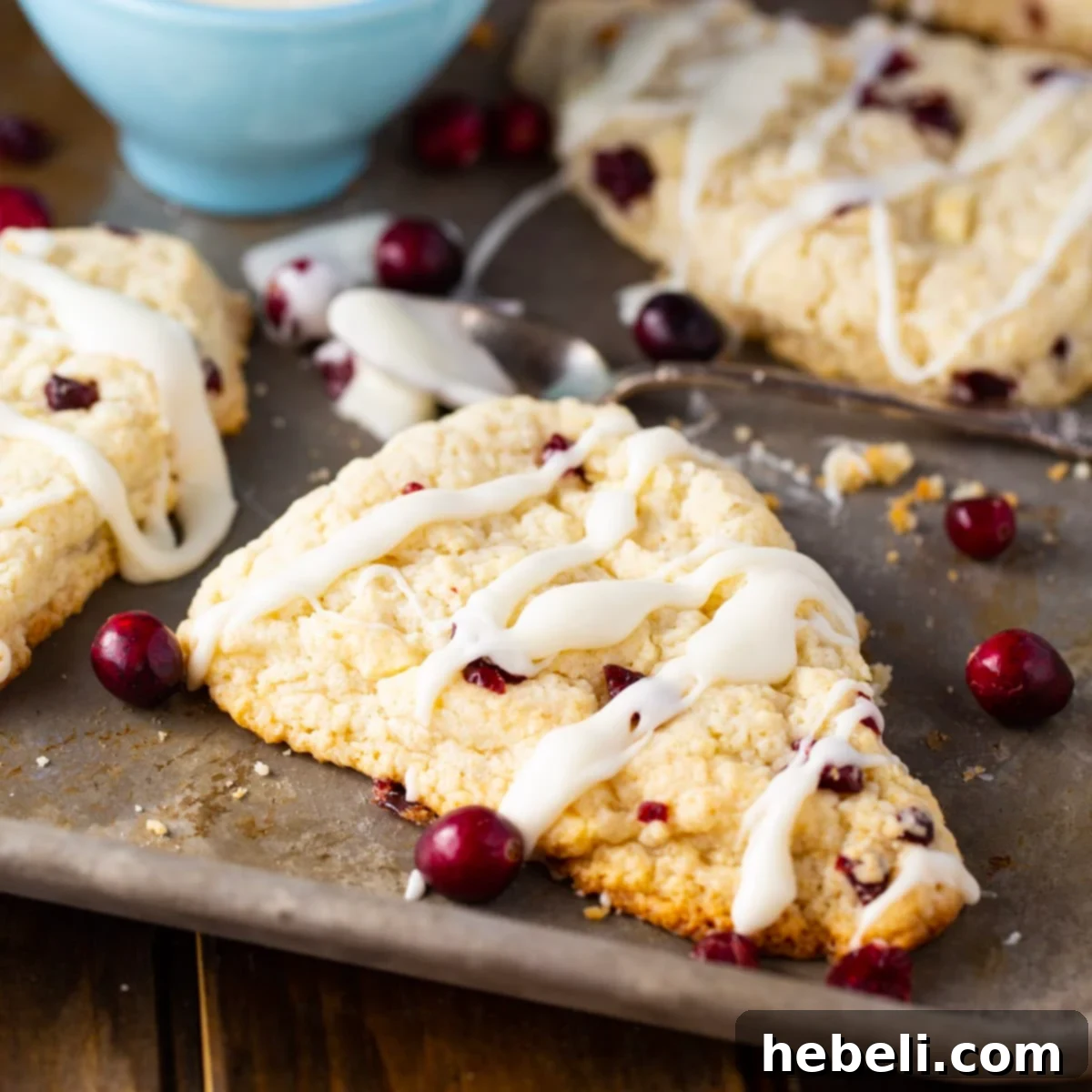 White Chocolate Cranberry Bliss Scones 2 Freshly baked Cranberry White Chocolate Scones on a baking sheet, golden brown and inviting.