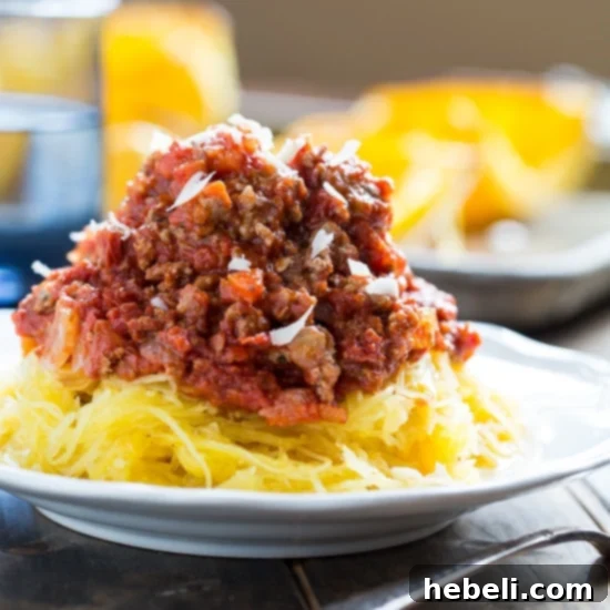 Spaghetti Squash with Spicy Meat Sauce served in a bowl, showing the squash strands covered in rich, red meat sauce.