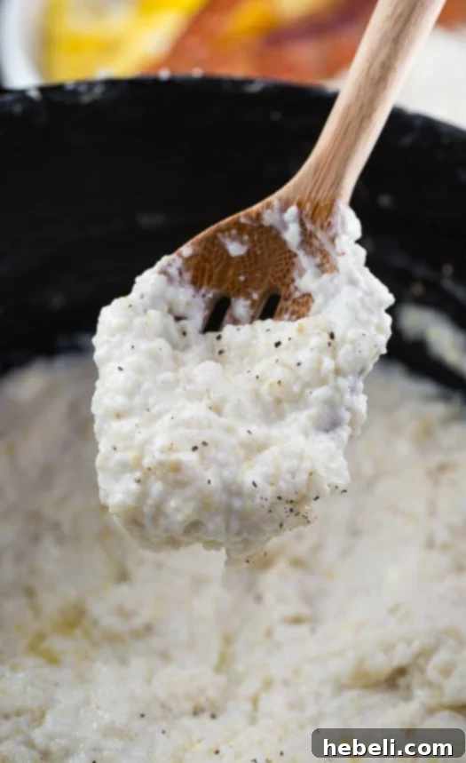Bowl of creamy Cream Cheese Grits, garnished and ready to eat.