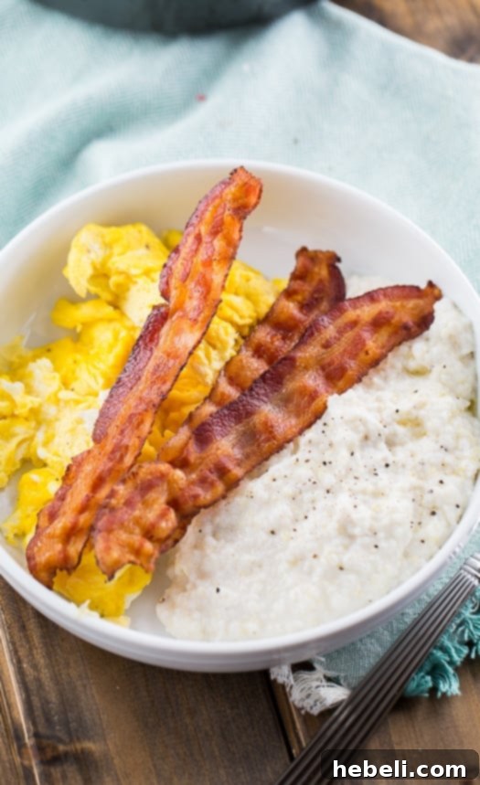 Cream Cheese Grits in a bowl with eggs and bacon.