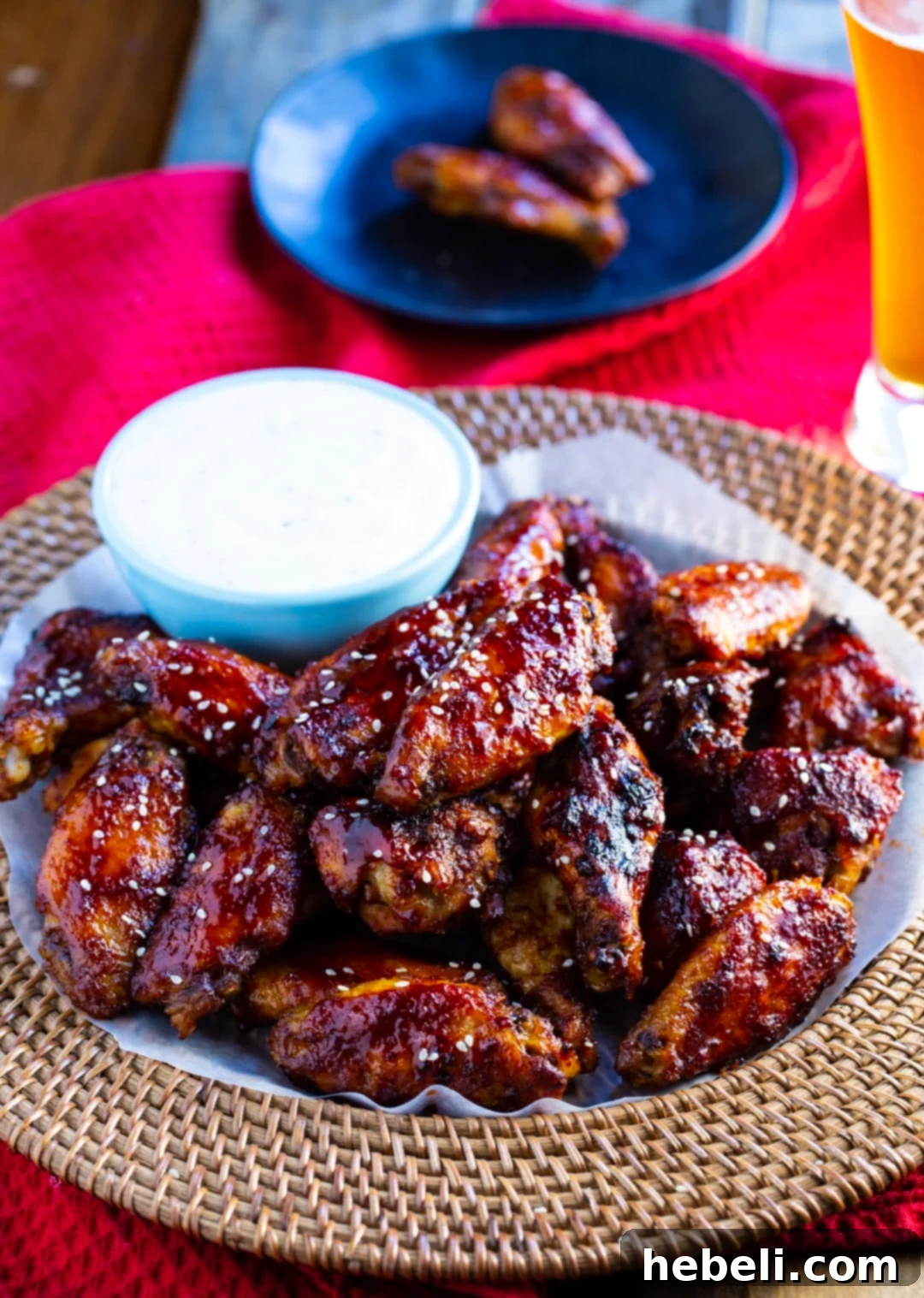 Slow Cooker Sweet Heat Glazed Wings 3 Wings on a serving tray with bowl of ranch dip.