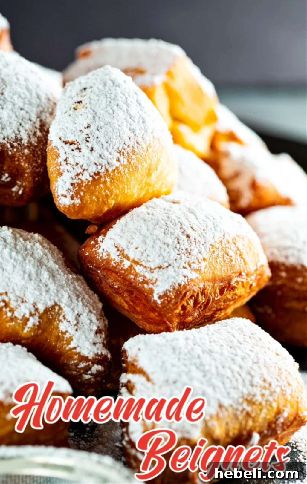 Pillowy Homemade Beignets 5 A close-up shot of perfectly fried, golden-brown Homemade Beignets, generously dusted with powdered sugar.