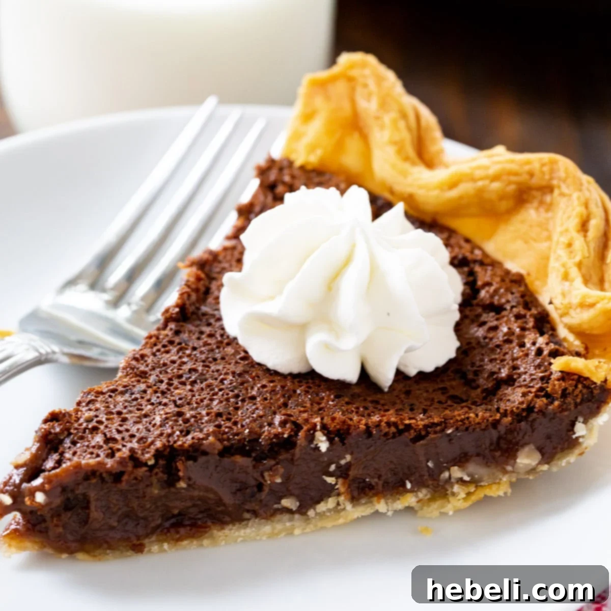 Decadent Chocolate Chess Pie 2 Slice of decadent Chocolate Chess Pie on a white plate, ready to be enjoyed.