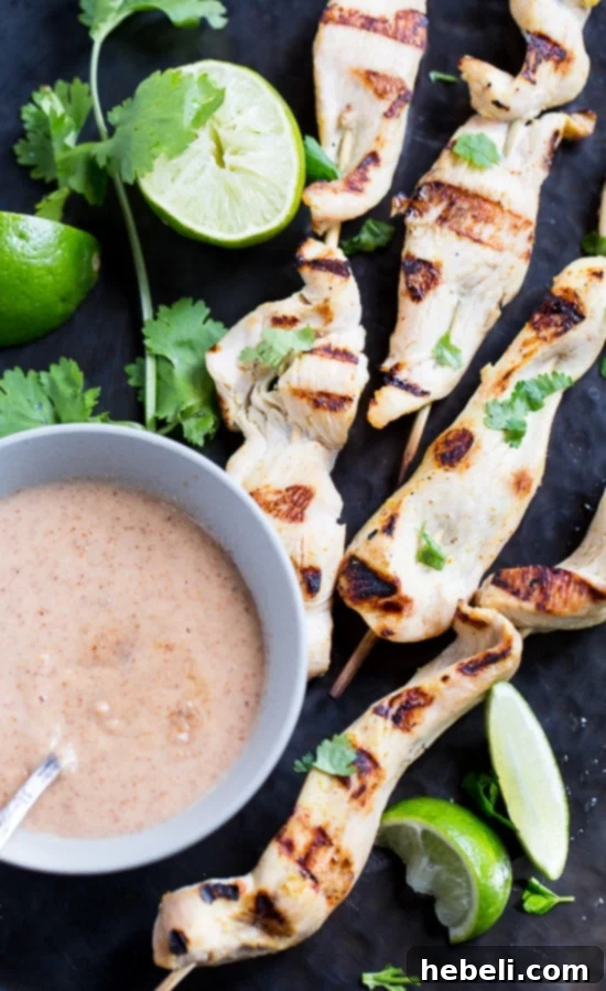 Creamy Almond Chicken Satay 3 Almond Butter Chicken Satay skewers with fresh lime and cilantro, showcasing the rich texture of the sauce