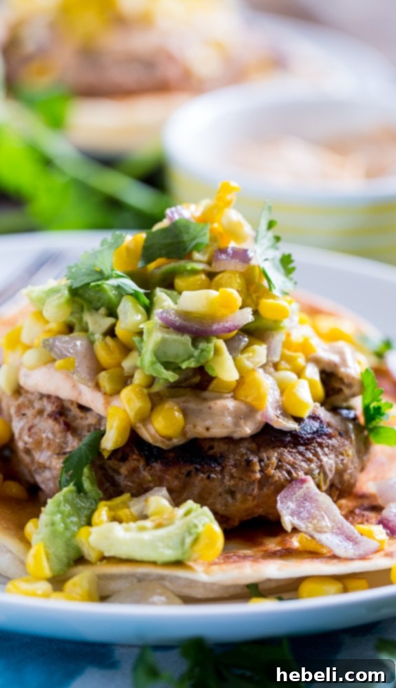 Top-down view of two Tex-Mex Turkey Burgers, showing the crispy tortillas, turkey patties, and fresh toppings