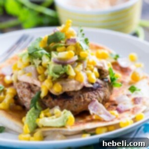 A finished Tex-Mex Turkey Burger with spicy mayo and avocado-corn salsa, ready to be served