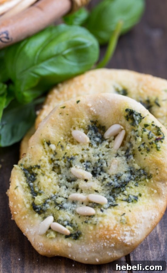 Mini Focaccia Bites 6 A hand reaching for a warm Biscuit Mini Focaccia from a plate, highlighting its perfect size for individual servings and immediate enjoyment.