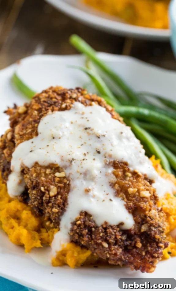 Plated Nutty Fried Chicken with Smashed Sweet Potatoes and Milk Gravy, ready to be enjoyed.