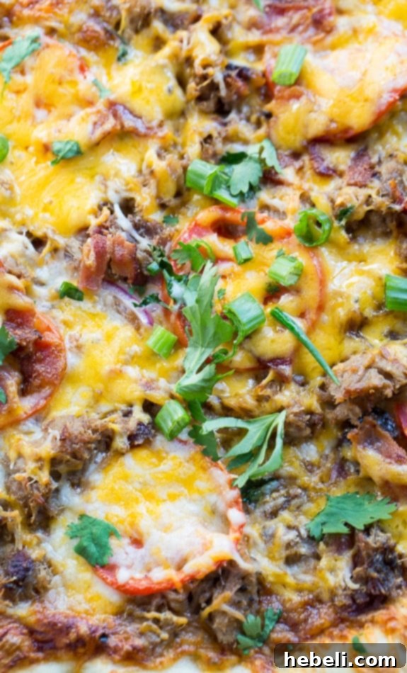 Close-up of a freshly baked Southern BBQ Pizza with Pulled Pork, showing melted cheese and toppings.