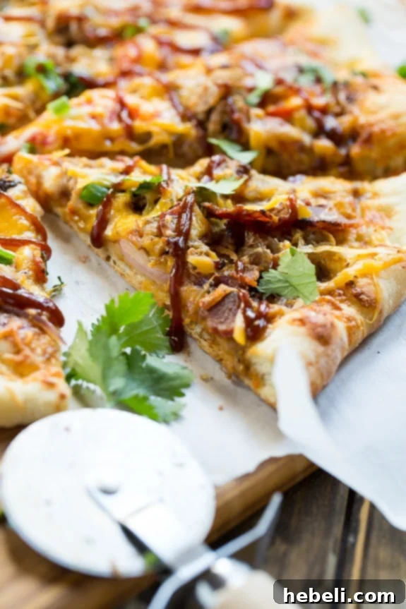Freshly baked Southern BBQ Pizza with Pulled Pork, sliced and ready to eat on a cutting board.