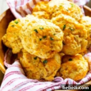 A bowl of freshly baked Red Lobster Cheddar Bay Biscuits, golden brown and garnished with parsley.