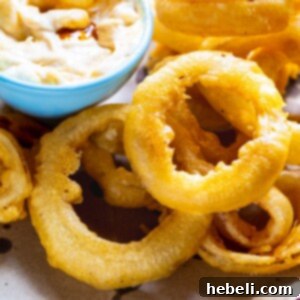 Beer Battered Onion Rings on a plate with dipping sauce.