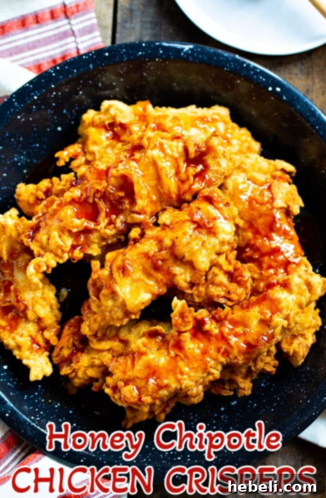 A large platter of Honey Chipotle Chicken Crispers with various dipping sauces and sides.
