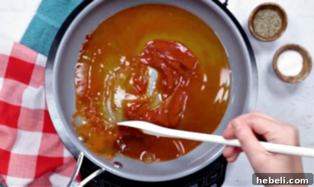 Mixing honey, chipotle, ketchup, and other ingredients in a saucepan to make the sauce.
