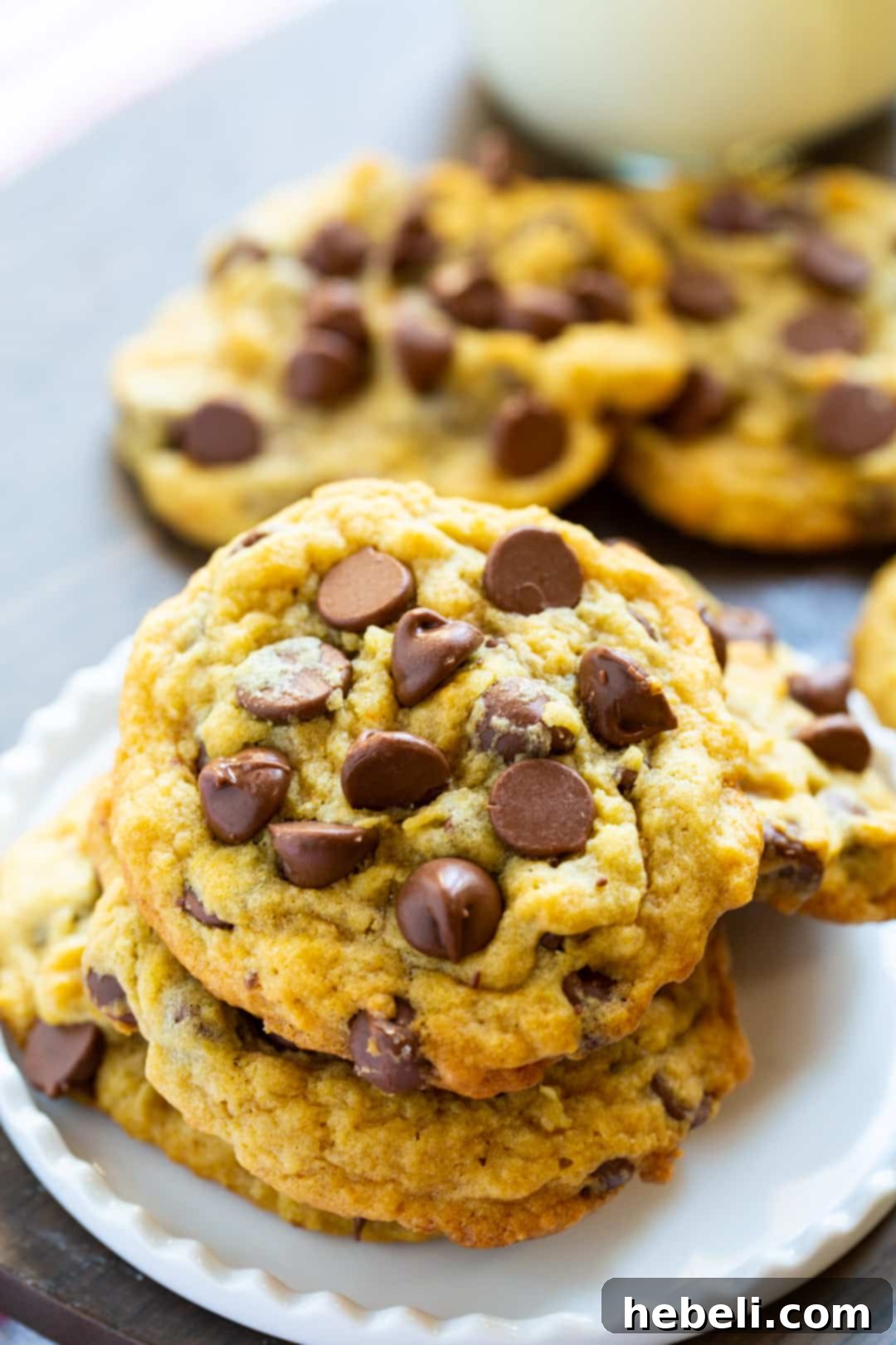 Stack of freshly baked Chocolate Chip Pudding Cookies on a white plate, showcasing their perfect shape and chocolate goodness.