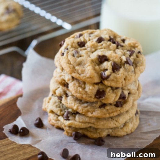 Close-up of a stack of golden-brown Chewy Chocolate Chip Cookies with melted chocolate chunks.