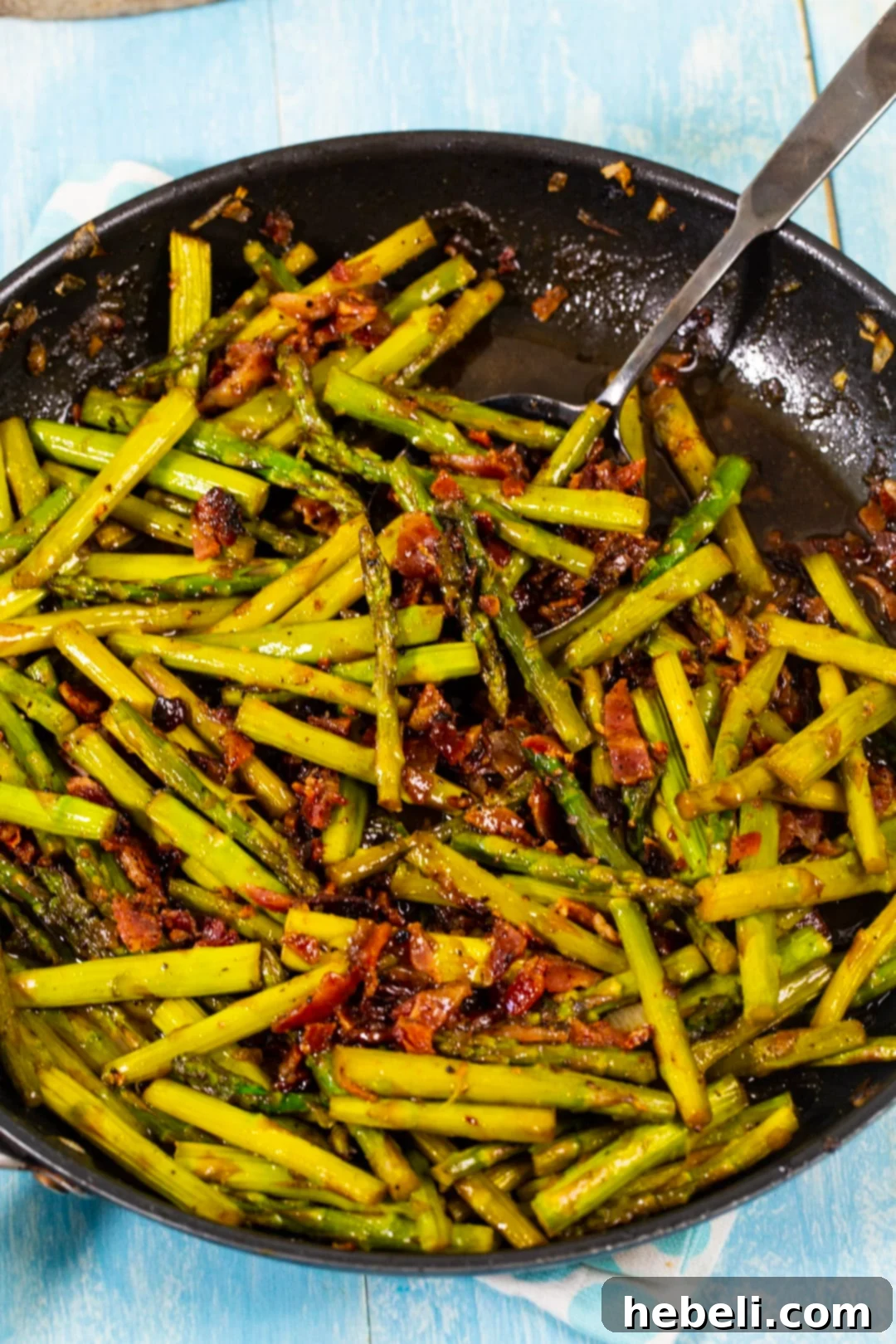 Asparagus and onions cooking in a skillet.