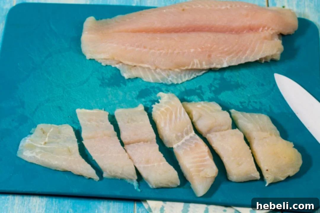 Catfish fillets cut into strips, ready for marinating and frying.