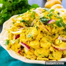 Curried Potato Salad topped with cilantro in a serving bowl.