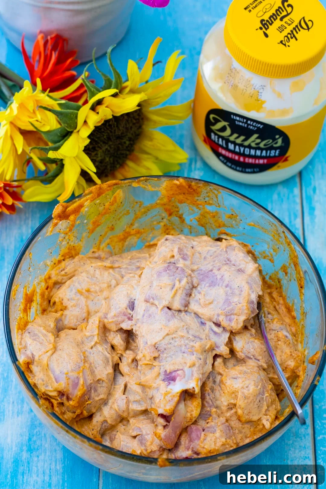Raw chicken in a bowl with marinade.