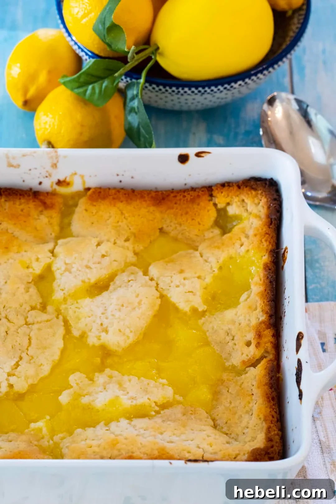 Warm Lemon Cobbler with Buttery Crust 3 Lemon Cobbler in a baking dish and bowl full of lemons.