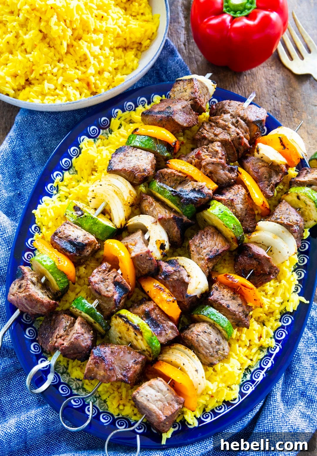 Garlic Marinated Beef Shish Kabobs on the Grill 3 Grilled Beef Shish Kabobs on a serving platter and a bowl full of rice.