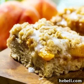 Peach Cobbler Bars with fresh peaches in background.