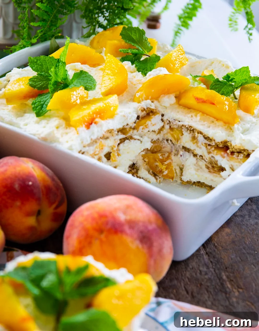 Peach Icebox Cake topped with fresh peach slices and mint sprigs.