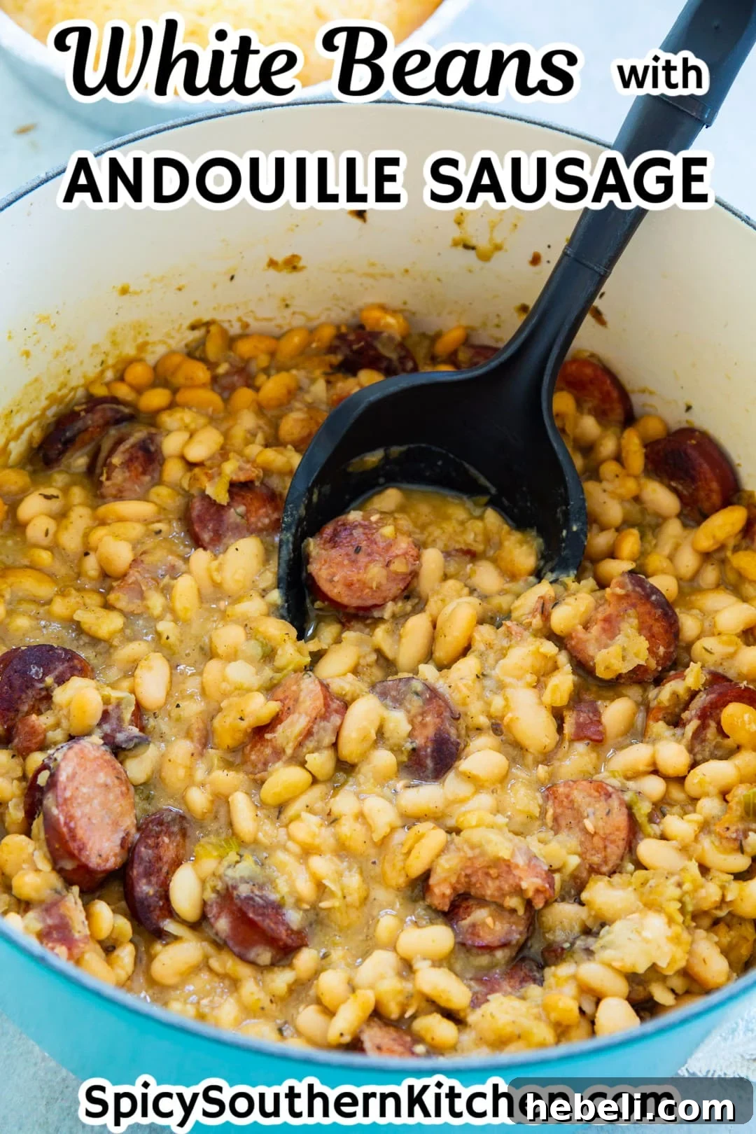 Spoon scooping White beans with sausage out of Dutch oven.